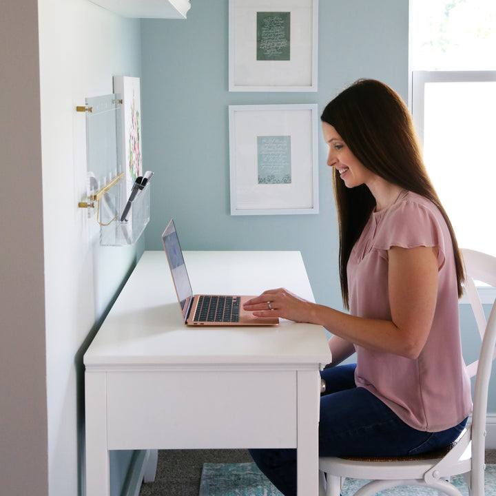 Woman sitting at a desk looking at a laptop computer with Evernote for going paperless